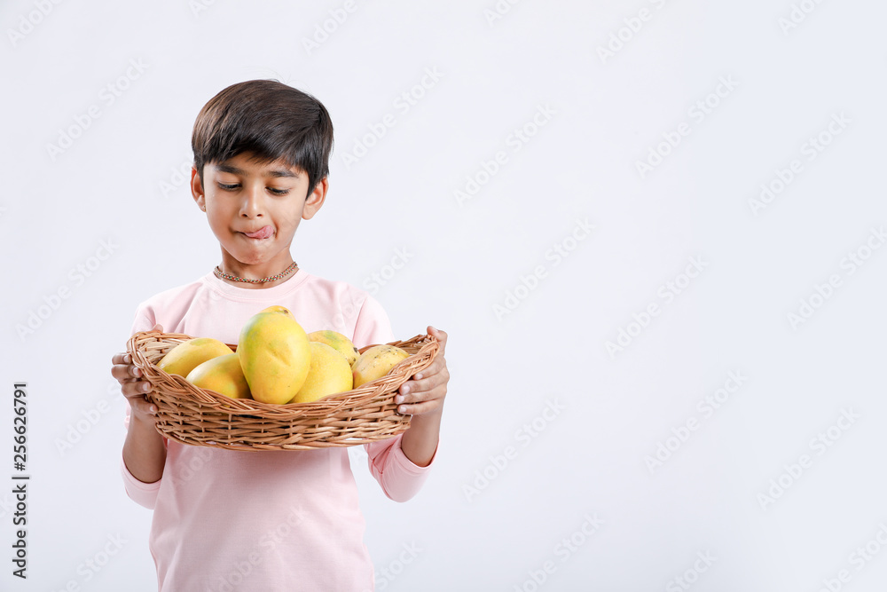Cute indian/Asian little boy holding Mango basket in hand and giving multiple expressions. isolated over white background Cute indian/Asian little boy holding Mango basket in hand and giving multiple expressions. isolated over white background