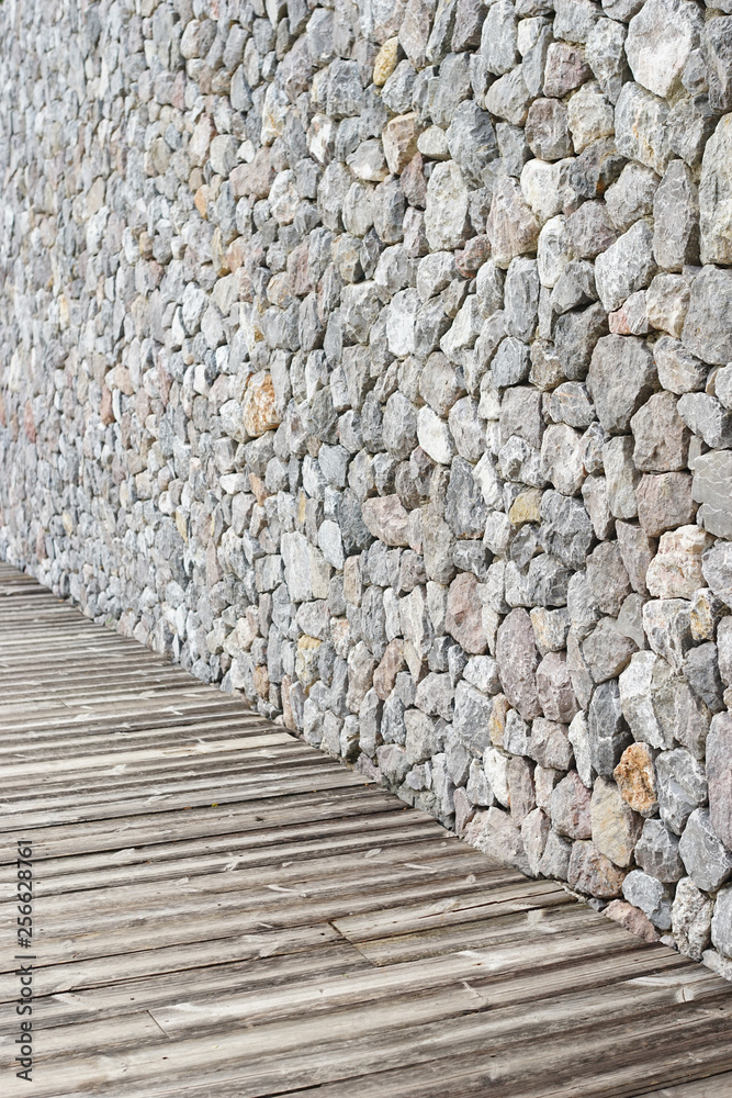 Fototapeta Drewniany chodnik z kamienną ścianą