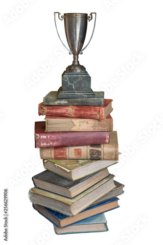 Stack of old vintage books with retro trophy on top isolated on white background