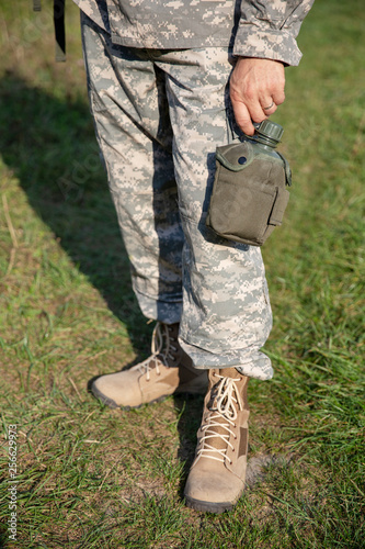 The soldier holds a flask
