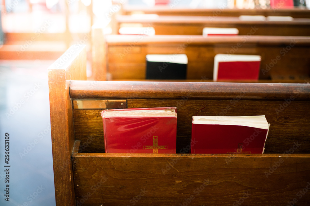 Bibles in wooden bench compartment in church, church service for Christian