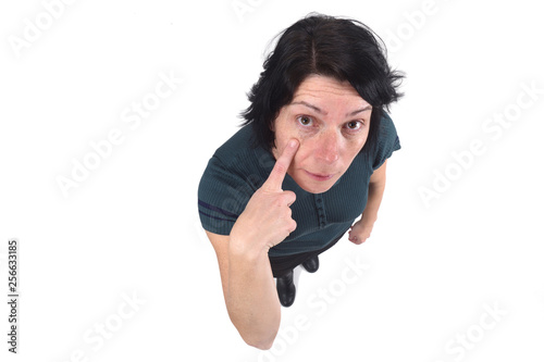 woman with finger on eye on white