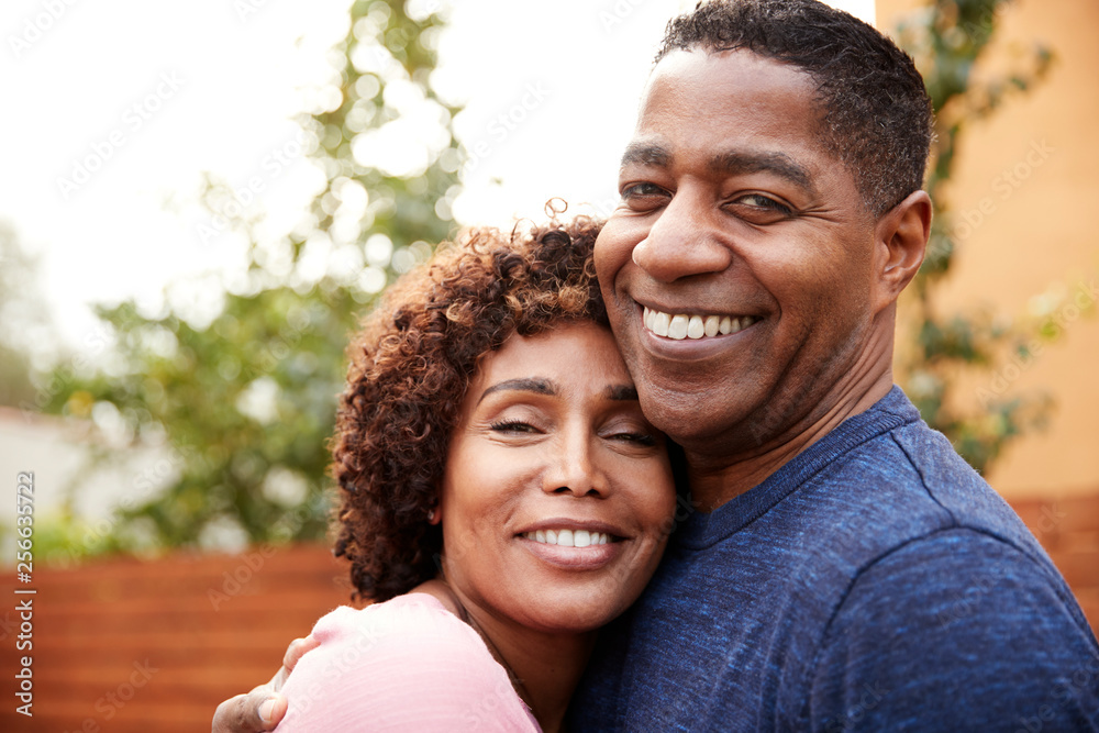 Happy middle aged black couple embracing smile to camera, close up Happy middle aged black couple embracing smile to camera, close up
