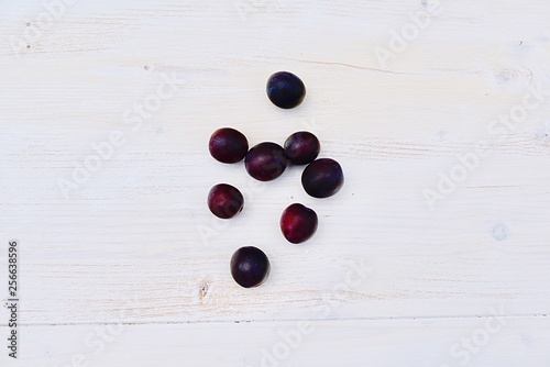 fresh plums on white wooden background