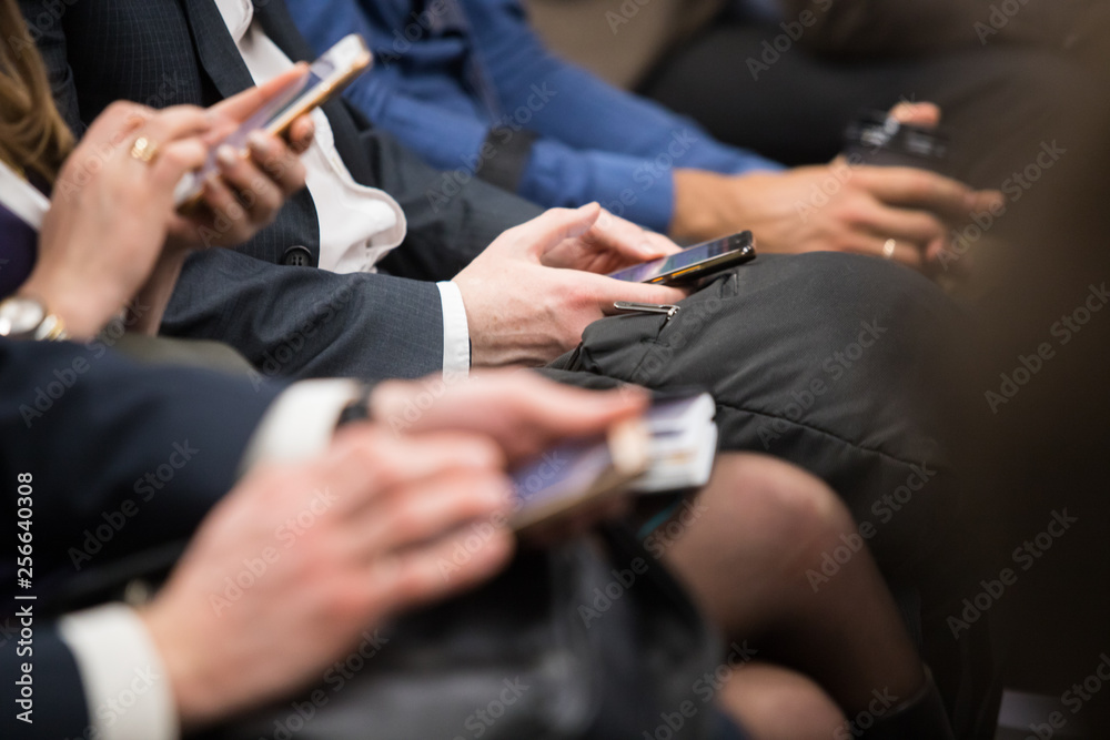 business people hands typing on smart phone during the seminar at conference room