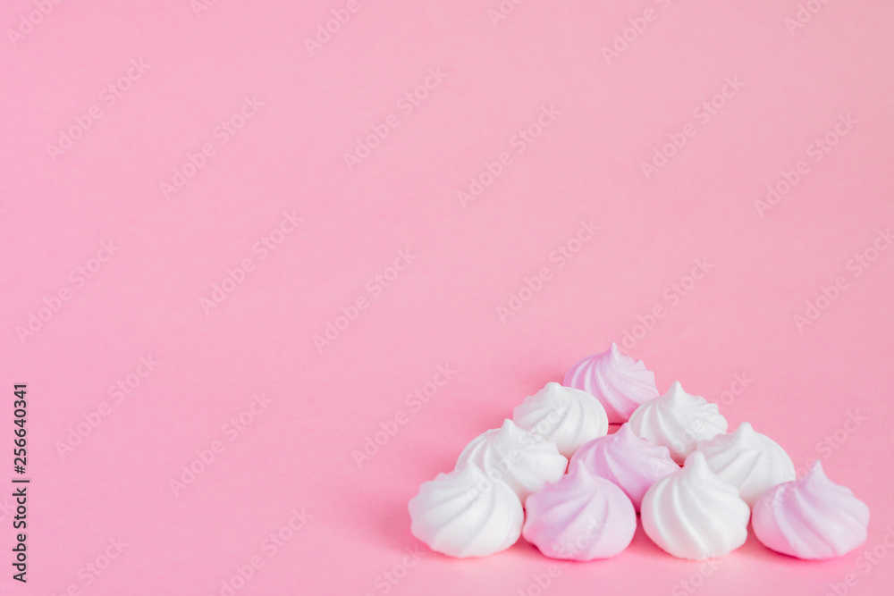 white and pink twisted meringues in porcelain bowl on pink background, greeting card, copy space