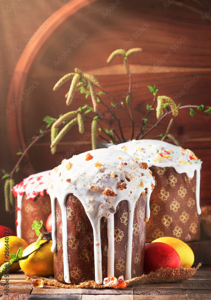 Traditional Russian Easter cake Kulich with colored golden yellow eggs,  decorated with candied fruits and nuts, with birch branches with shoots.  Vintage wooden table Stock Photo | Adobe Stock