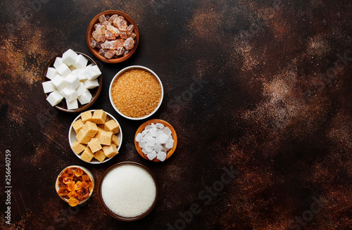 Set of different white and brown sugar in assortment, dark background, top view
