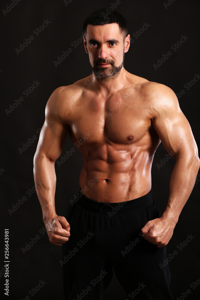Portrait of young handsome  muscular bodybuilder on black background  torso close up view 
