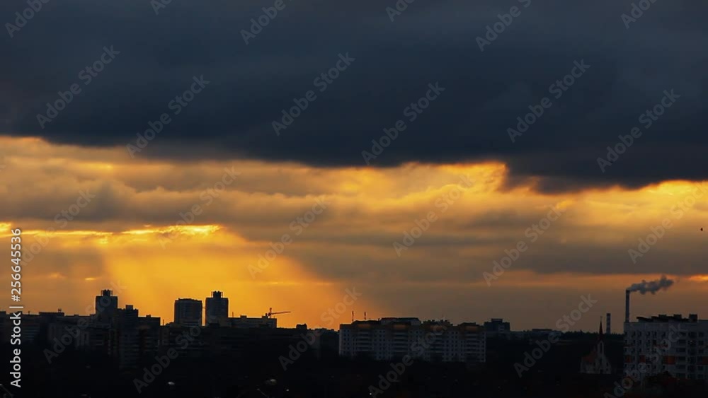dramatic time-lapse  of clouds and sun on the city skyline