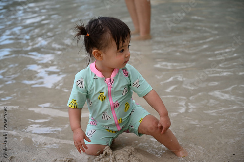 人工ビーチで砂遊びをする幼児