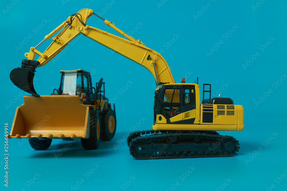 Excavator and Wheel loader model isolated on cyan background in industrial construction Excavator and Wheel loader model isolated on cyan background in industrial construction