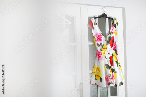 Beautiful colored dress hanged on white door