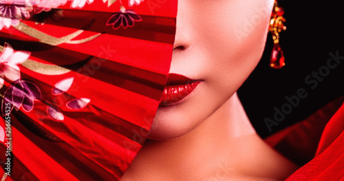 Foto beautiful Japanese girl in kimono with a fan on a black background