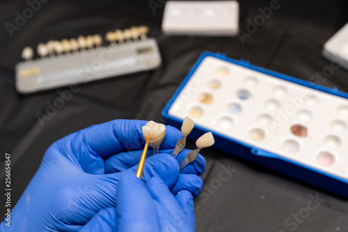 Dentist is painting a tooth crown in dental laboratory