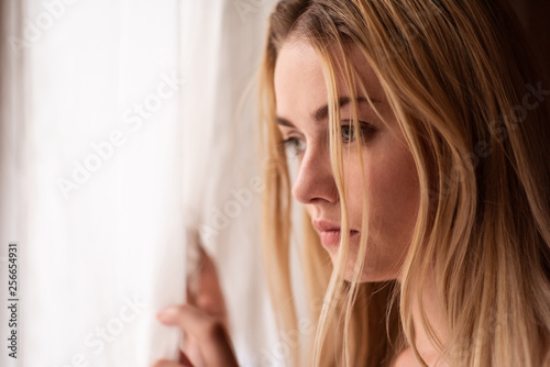 Woman looking outside through window