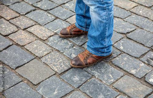 Legs of men in jeans on the pavement