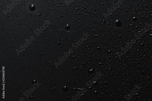 Black surface with clear water drops, background