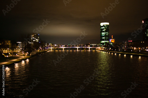 Bright view on the night city  river and skyscraper.