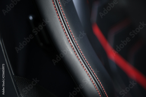 Red stitching on black leather car seat