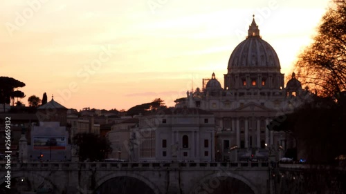 Rome, dramatic orange sunset behind the Vatican Dome with birds flying