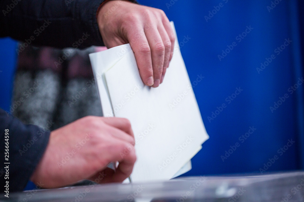 Illustrative image of the election in a democratic society. Elections in Ukraine. The process of voting at a polling station. The voter throws the ballots in the ballot box. Illustrative image of the election in a democratic society. Elections in Ukraine. The process of voting at a polling station. The voter throws the ballots in the ballot box.