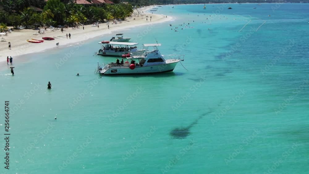 Beautiful Caribbean sea fly over while happy people load a dive boat in the warm sun Beautiful Caribbean sea fly over while happy people load a dive boat in the warm sun