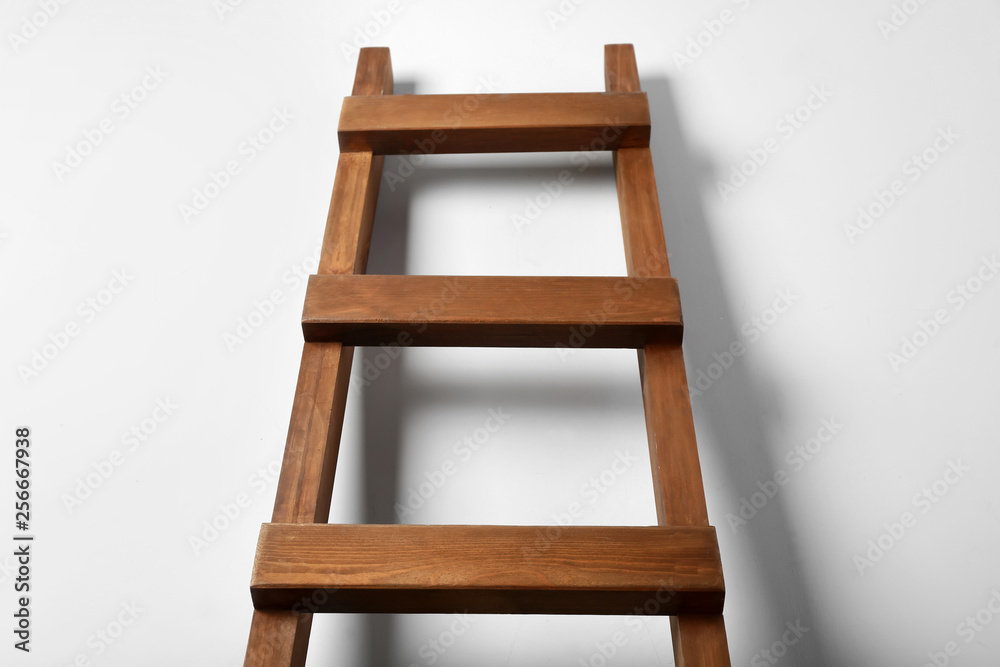 Wooden ladder near light wall. Concept of career growth Wooden ladder near light wall. Concept of career growth