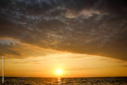 Golden  Fiery sunset on the Black Sea  on the beach. Coast  stones  waves  sun  beautiful sky  clouds. August  Batumi  Georgia. Water  ease  game.