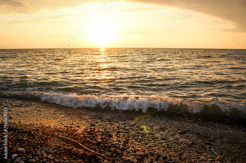 Golden, Fiery sunset on the Black Sea, on the beach. Coast, stones, waves, sun, beautiful sky, clouds. August, Batumi, Georgia. Water, ease, game.