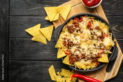 Tasty Mexican dish with nachos on table photo