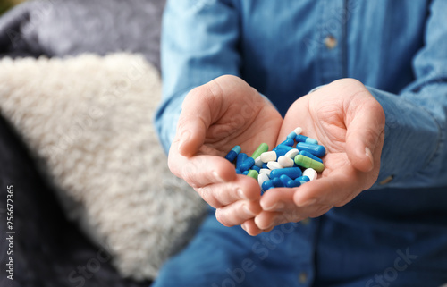 Woman with pills at home, closeup