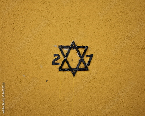 House number with Star of David on a yellow wall. Rivadavia Jewish Sephardic Quarter, Spain. photo