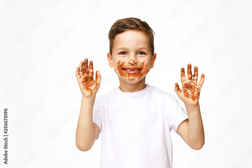little boy with face and hands in chocolate little boy with face and hands in chocolate