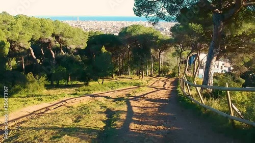 Drone flying backwards and up in the woods revealing barcelona view from sarria uptown photo