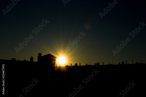 Sol que se esconde tras los edificios