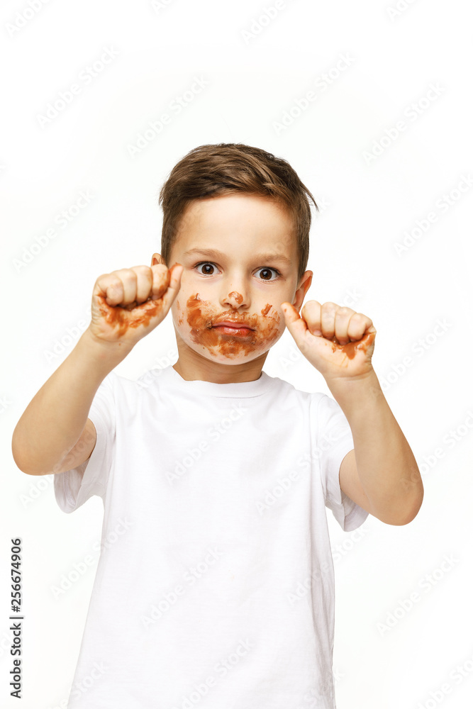 little boy with face and hands in chocolate little boy with face and hands in chocolate