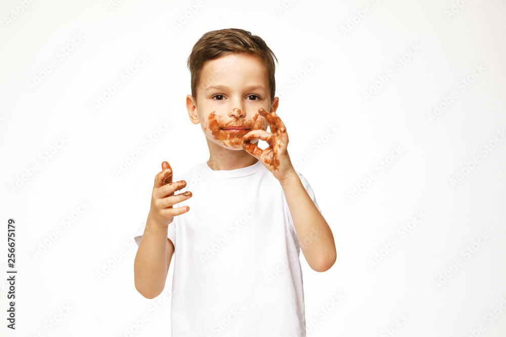 little boy with face and hands in chocolate little boy with face and hands in chocolate