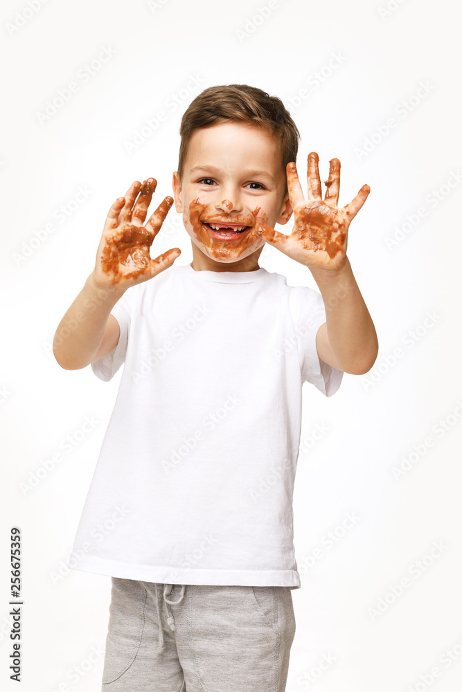 little boy with face and hands in chocolate little boy with face and hands in chocolate