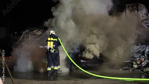 firefighter extinguish a huge carfire with huge flames photo