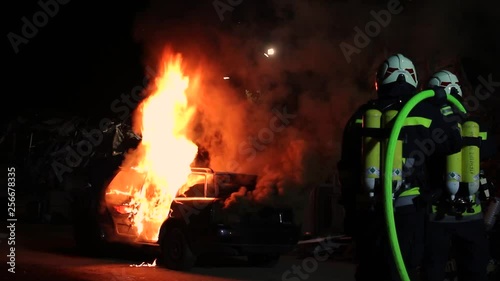 a car is burning fire firefighters extingusih the flames firefighter photo