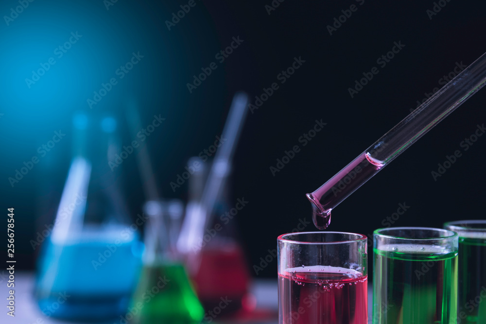 Researcher with glass laboratory chemical test tubes with liquid for analytical , medical, pharmaceutical and scientific research concept.