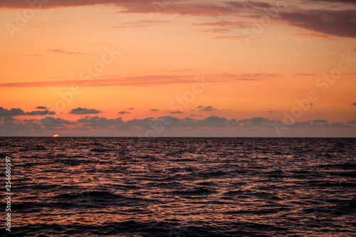 Golden  Fiery sunset on the Black Sea  on the beach. Coast  stones  waves  sun  beautiful sky  clouds. August  Batumi  Georgia. Water  lightness  play. Pink  lilac  crimson