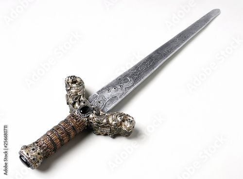 Closeup of vintage metal sword decorated with gems on white background