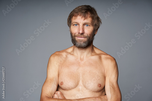 mature man shirtless standing with folded hands