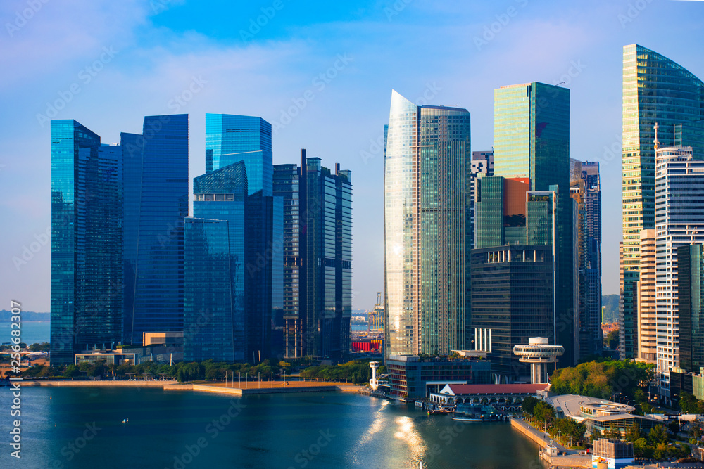 Fototapeta premium Singapore city skyline in business travel district and office building with beautiful sky.