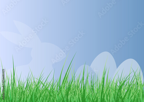 easter background with easter bunny and egg silhouette behind lush fresh green grass against blue