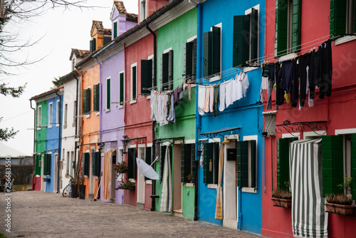 Colorful houses of Burano island near Venice, Italy Laundry on the clothes line. Features old multicolored houses.