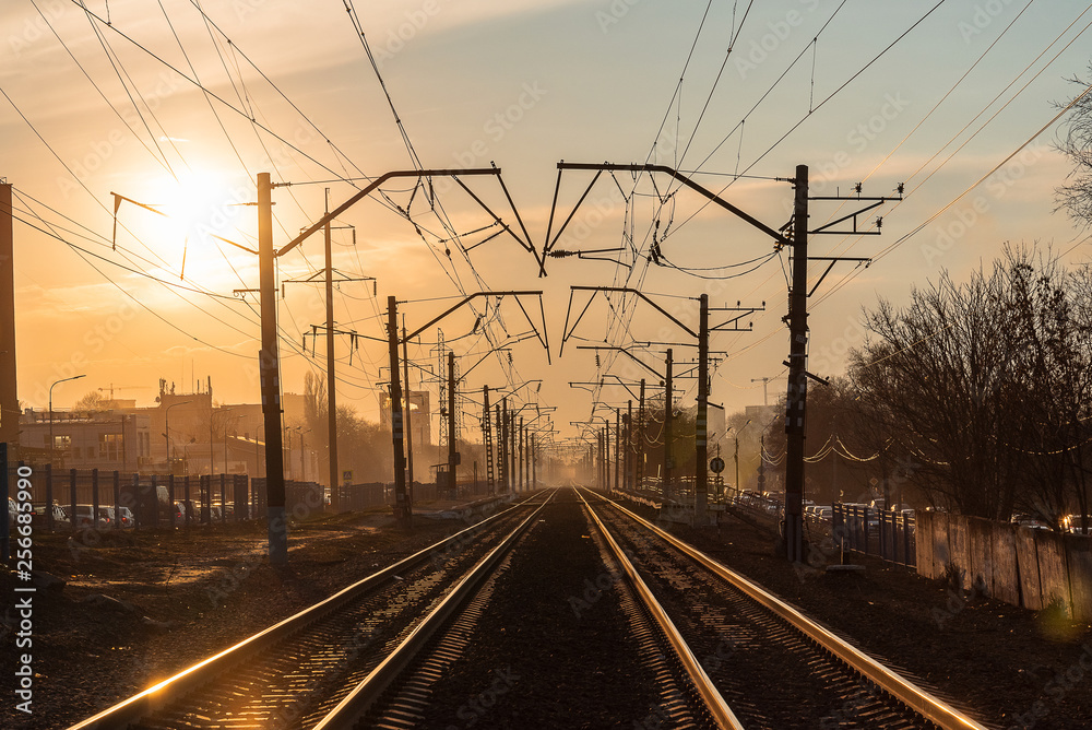 railway rails in the evening in the light of the sun at sunset in early spring