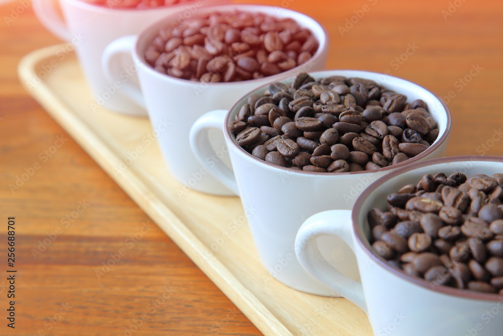 Full cups of heap coffee bean on wooden table with copy space Full cups of heap coffee bean on wooden table with copy space